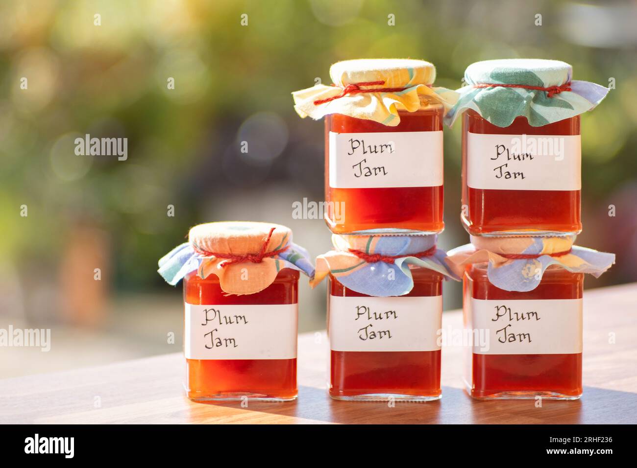 Barattoli di marmellata di prugne fatte in casa. Le vaschette di vetro hanno etichette scritte a mano chiare e le vaschette sono dotate di un rivestimento in tessuto Foto Stock