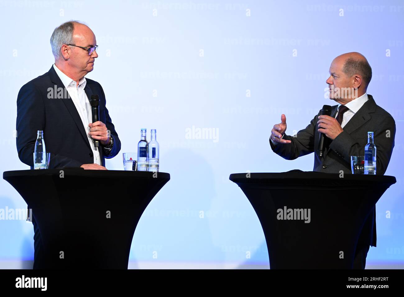 Duesseldorf, Germania. 16 agosto 2023. Il Cancelliere Olaf Scholz (SPD, r) parla con Andreas Tyrock, caporedattore della Westdeutsche Allgemeine Zeitung, sul podio al North Rhine-Westphalia Entrepreneurs' Day. Credito: Federico Gambarini/dpa/Alamy Live News Foto Stock