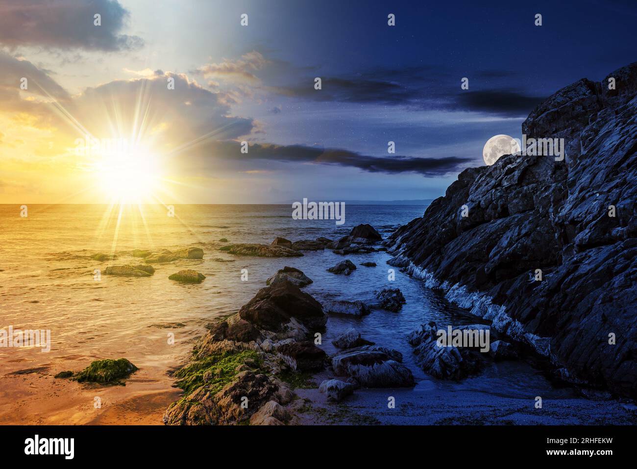 grandi massi e alghe marine sulla costa rocciosa del mare con sole e luna al crepuscolo. il concetto cambia giorno e notte. misterioso scen di campagna Foto Stock