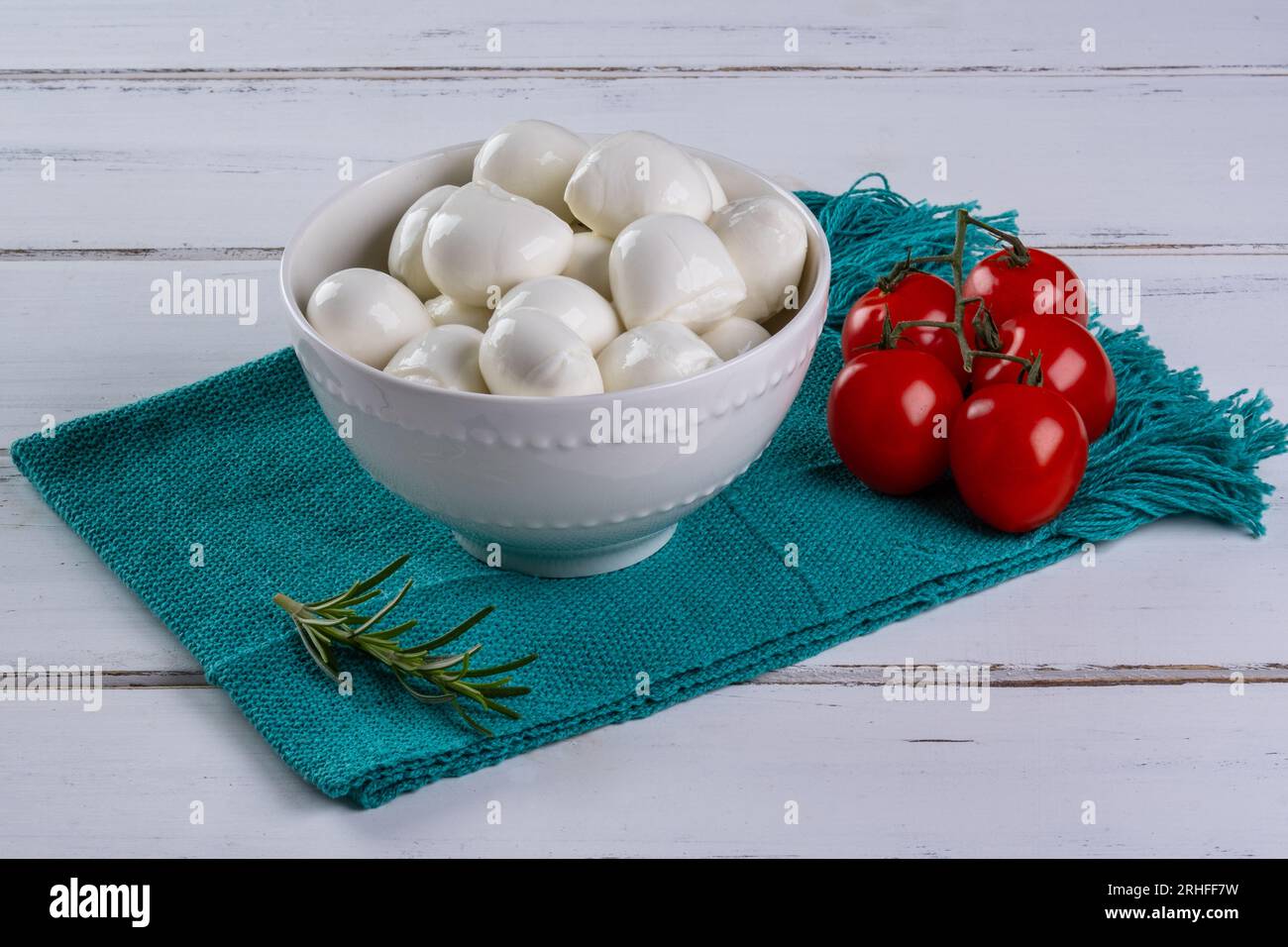 ciotola con palle di mozzarella di bufala e pomodori ciliegini a lato. Foto Stock