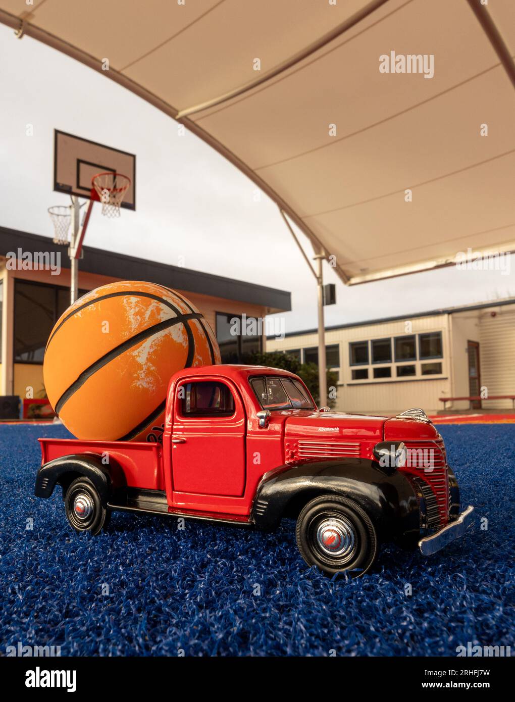 Piccolo camion rosso con una pallina arancione sul retro. Foto Stock