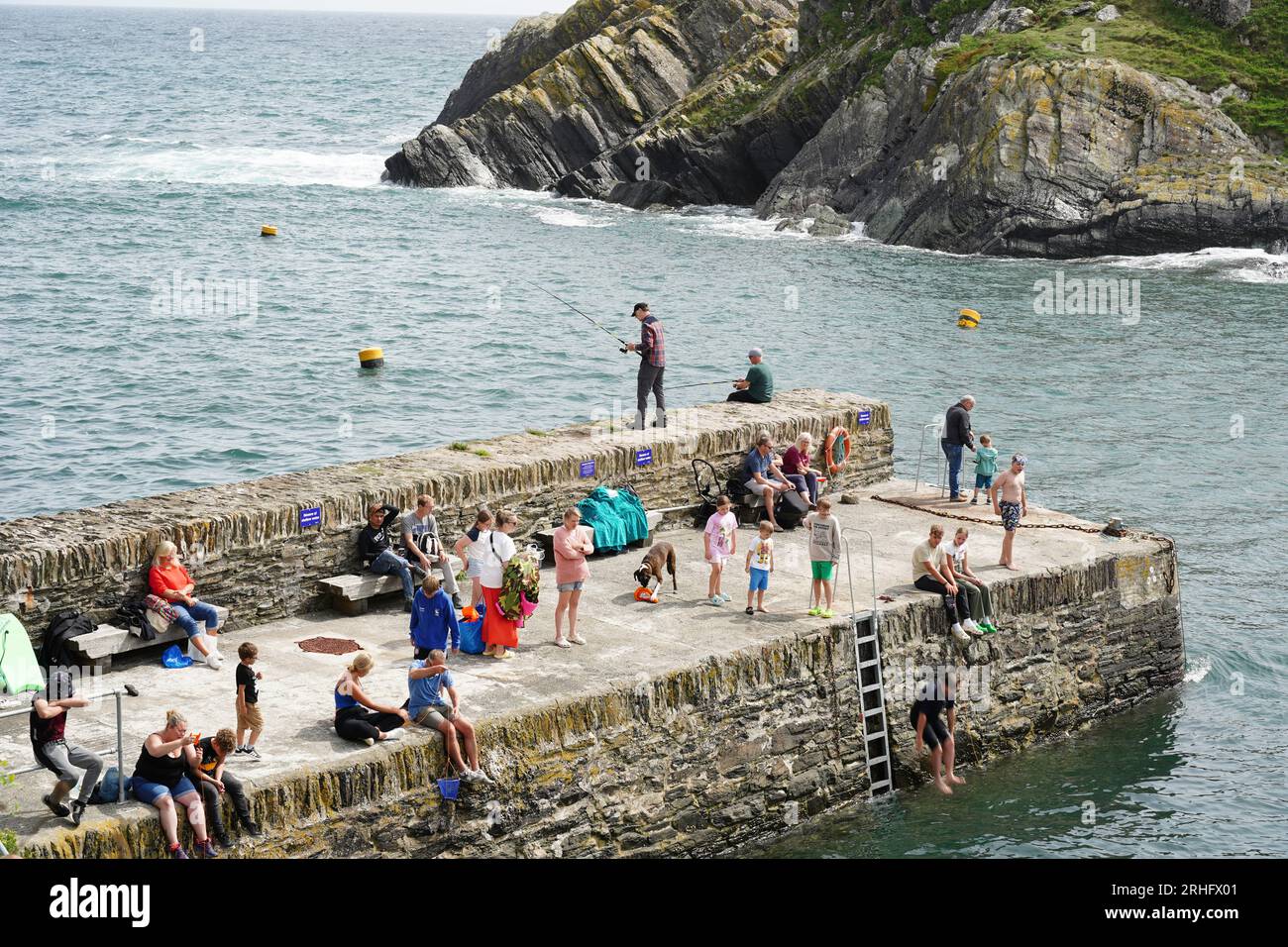 Polperro, Regno Unito - agosto 2023: Le famiglie si godono il sole e il mare al porto di Polperro Foto Stock