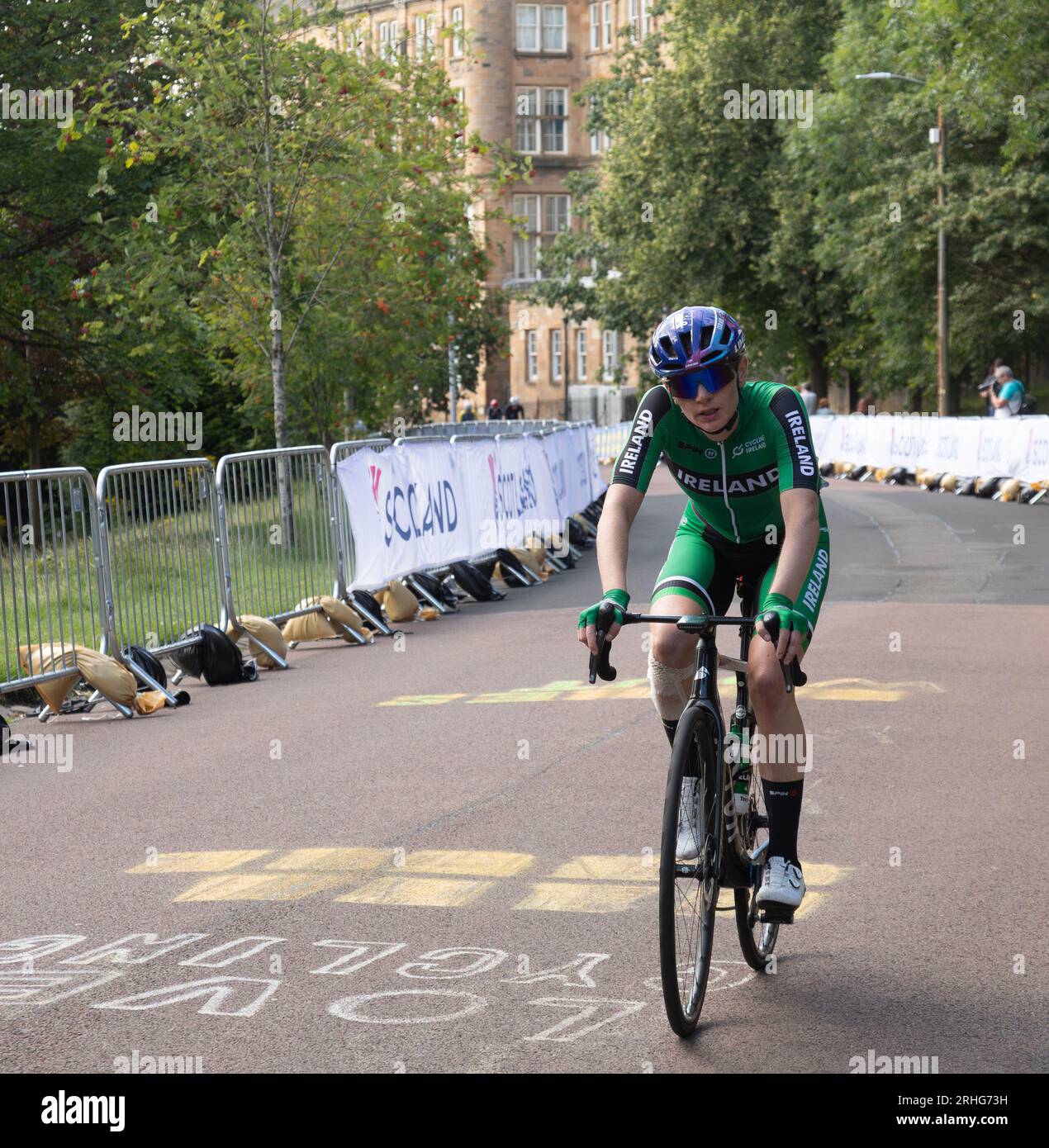 Alice Sharpe, irlandese, cavalca un cartello con la scritta "Love Cycling" mentre gareggia nella gara di campionato del mondo femminile UCI 2023. Foto Stock