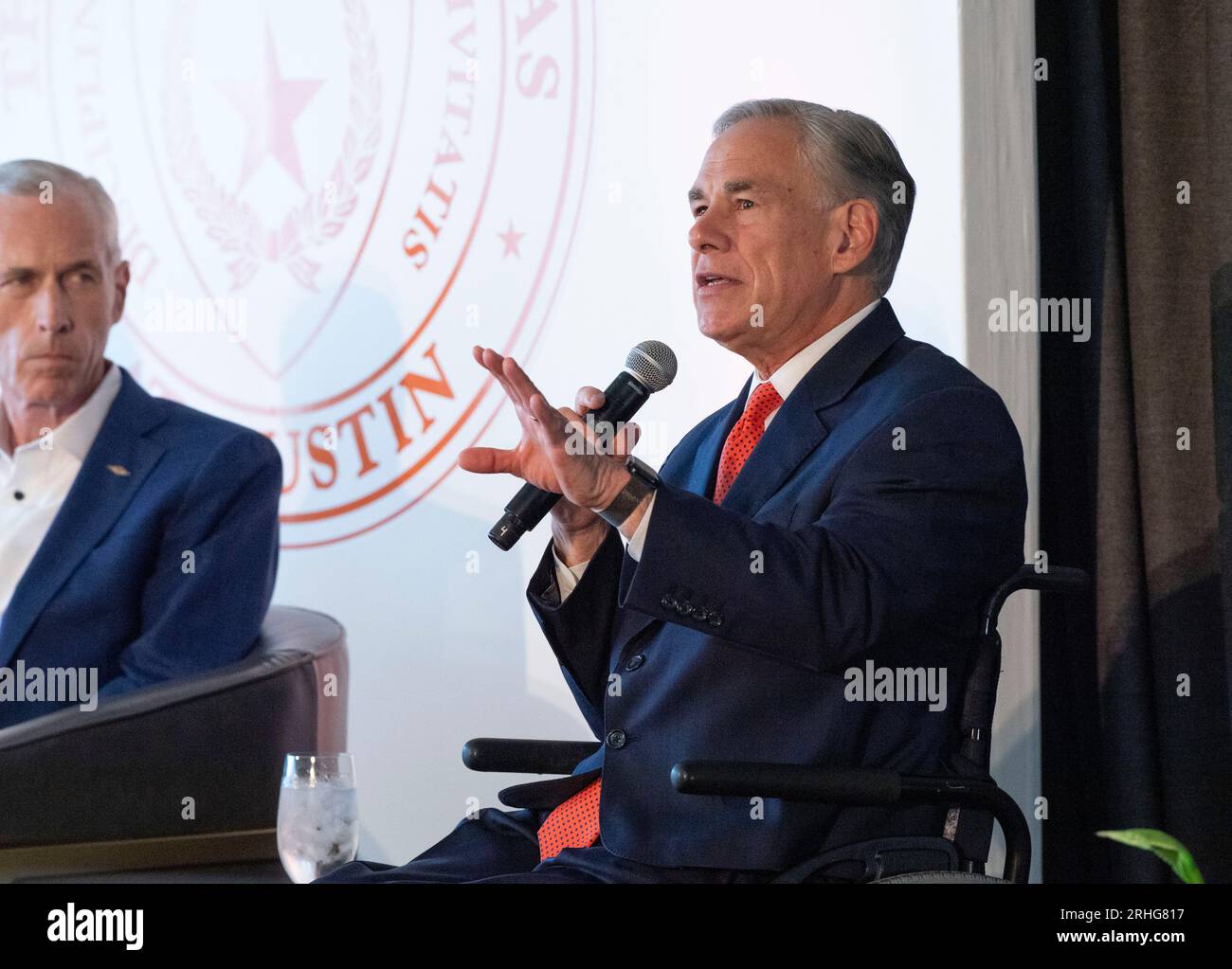 Austin Texas USA, 16 agosto 2023: Il governatore del Texas GREG ABBOTT parla come il CEO di Dow JIM FITTERLING ascolta durante una discussione sull'importanza dello sviluppo della tecnologia nucleare e dell'energia in Texas. Il piano è incentrato su piccoli reattori modulari (SMR) di capacità di 80 megawatt che, in gruppi, alimenterebbero le esigenze delle grandi raffinerie chimiche del Texas lungo la costa del Texas. ©Bob Daemmrich Foto Stock