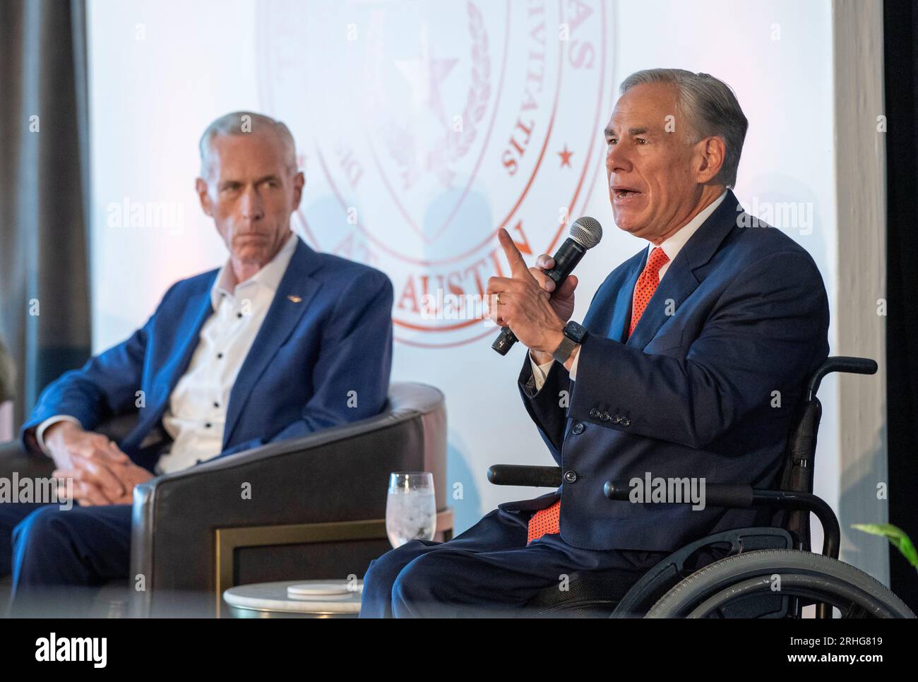 Austin Texas USA, 16 agosto 2023: Il governatore del Texas GREG ABBOTT parla come il CEO di Dow JIM FITTERLING ascolta durante una discussione sull'importanza dello sviluppo della tecnologia nucleare e dell'energia in Texas. Il piano è incentrato su piccoli reattori modulari (SMR) di capacità di 80 megawatt che, in gruppi, alimenterebbero le esigenze delle grandi raffinerie chimiche del Texas lungo la costa del Texas. ©Bob Daemmrich Foto Stock