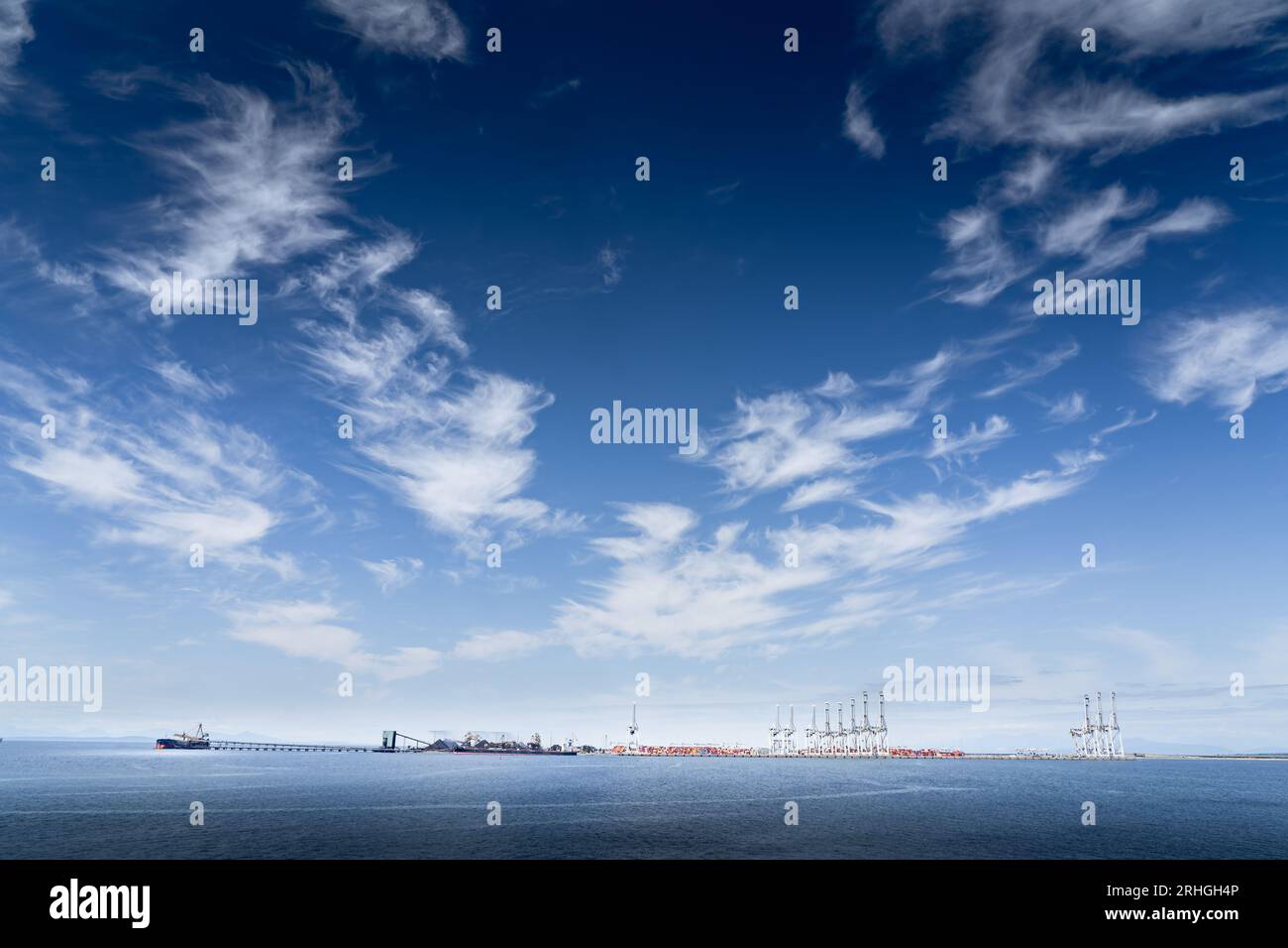 Riprese grandangolari di cargo ancorati al largo dell'Isola di Vancouver Britishish Columbia sotto un suggestivo cielo blu che si affaccia sulla Penisola di Washing. Foto Stock