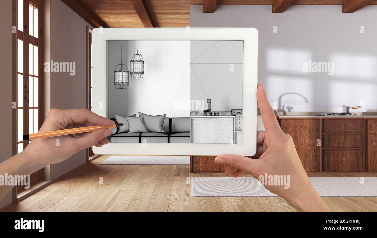 Mani che tengono e disegnano su un tablet che mostra la cucina e il soggiorno in stile boho con dettagli CAD schizzo. Interni rifiniti sullo sfondo, arco Foto Stock
