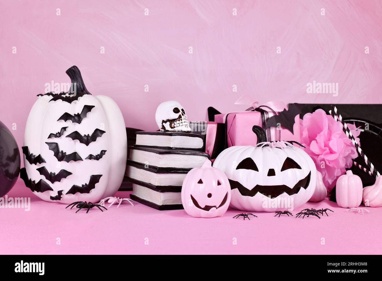 Moderno decor rosa di Halloween con zucche bianche e nere, libri di magia e ragni con spazio copia Foto Stock