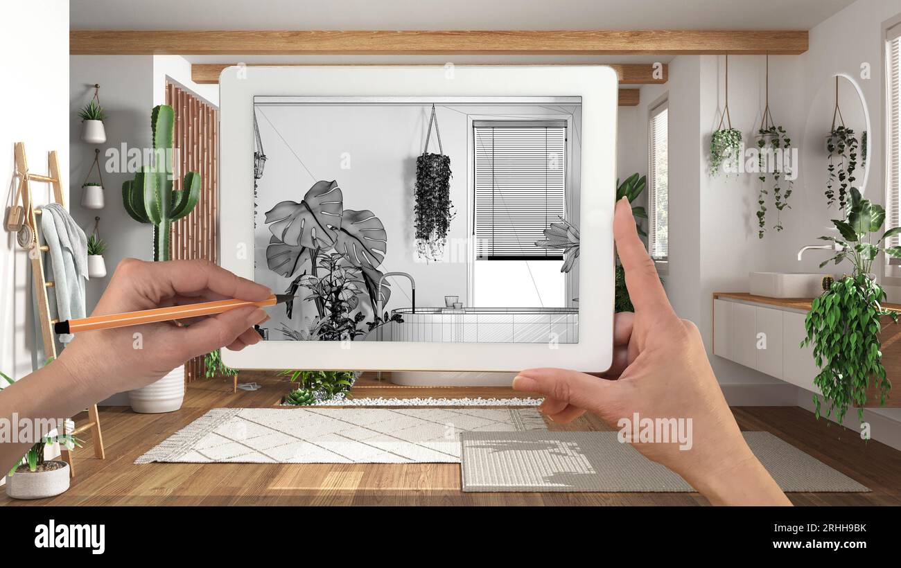 Mani che tengono e disegnano su un tablet che mostra il bagno con piante domestiche, dettagli disegno CAD. Interni con finiture reali sullo sfondo, architettura desi Foto Stock