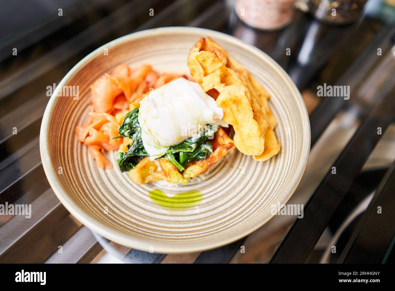 Cialde di patate, uova in camicia, crema di avocado con salmone e uova. Colazione sana, proteine. Piatto del ristorante. Foto Stock