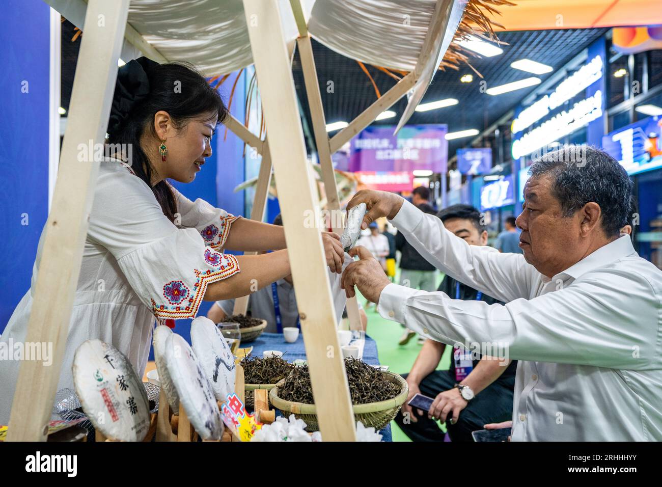 Kunming, provincia cinese dello Yunnan. 17 agosto 2023. Un visitatore (R) acquista prodotti da tè durante il primo South Asia Tea Festival alla settima China-South Asia Expo a Kunming, nella provincia dello Yunnan della Cina sud-occidentale, 17 agosto 2023. Il primo Festival del tè dell'Asia meridionale ha avuto inizio giovedì durante la settima esposizione Cina-Asia meridionale, presentando la cultura del tè e promuovendo i prodotti del tè. Credito: HU Chao/Xinhua/Alamy Live News Foto Stock