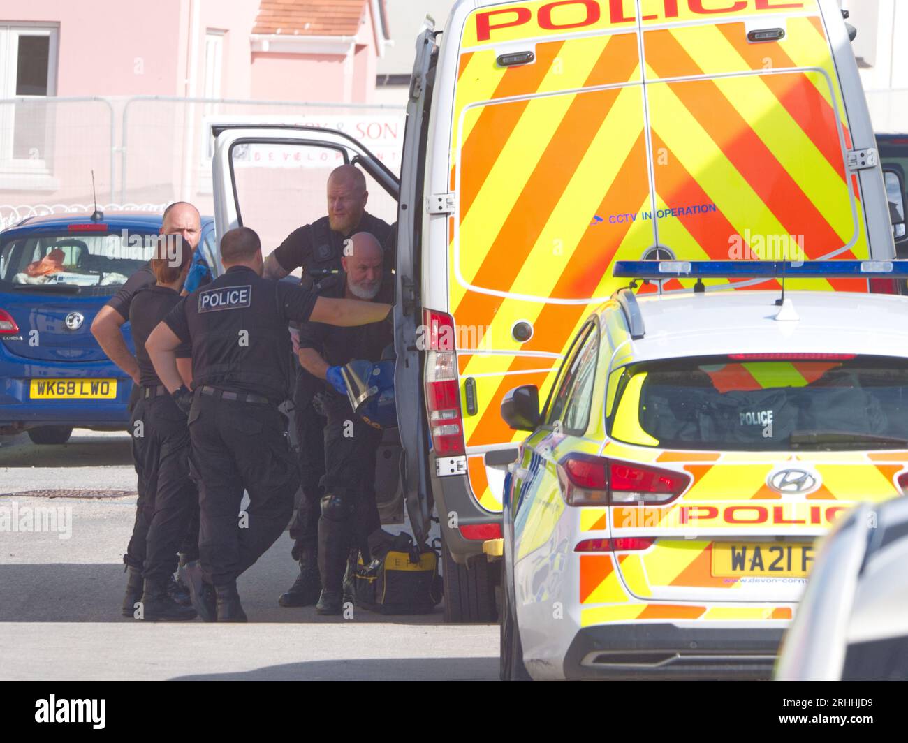 Diversi agenti di polizia accompagnati da un cane da sniffer vengono visti mentre fanno un ingresso forzato in una casa situata su Stret Kosti Veur Woles. Questa posizione si trova nel villaggio modello del progetto King Charles alla periferia di Newquay. Un testimone oculare ha riferito che la porta d'ingresso era rotta per accedere. Un certo numero di individui sono stati visti essere scortati da agenti di polizia. La polizia di Devon e Cornovaglia fanno un raid per droga. Nansledan Cornwall Regno Unito. 17 agosto 2023. Robert Taylor Foto Stock