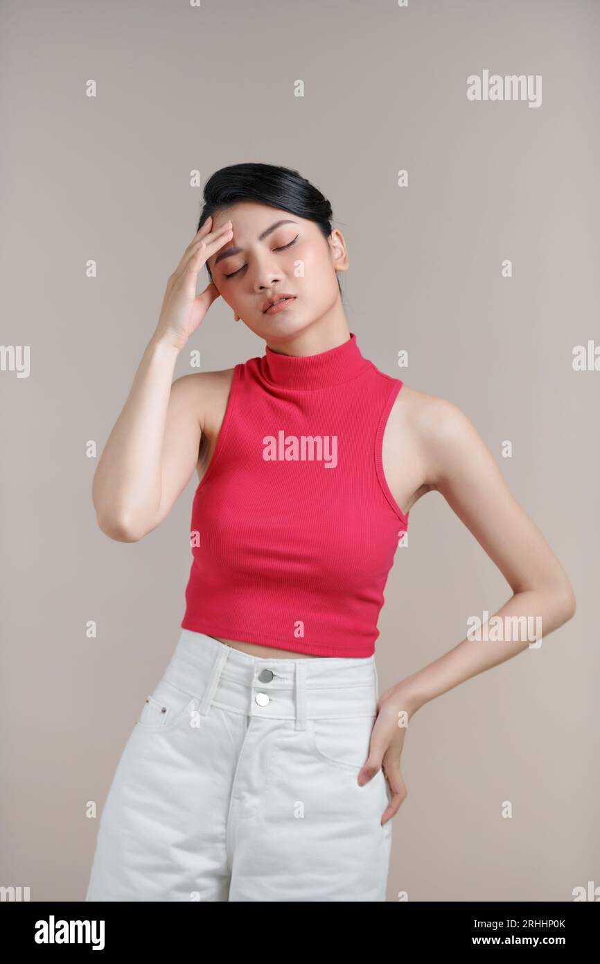 Giovane donna che soffre di mal di testa disperata e stressata perché dolore ed emicrania. Mani sulla testa. Foto Stock