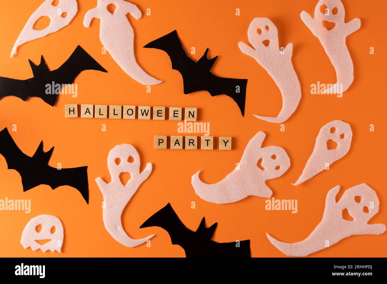 Fantasmi bianchi e mazza per la festa di Halloween. Immagine fantasma della carta di avvolgimento su sfondo arancione vista dall'alto. Fumetto Creepy Whisper. Fai-da-te fatto a mano. Impostare i caratteri boo. Parola frase di legno della lettera. Foto Stock