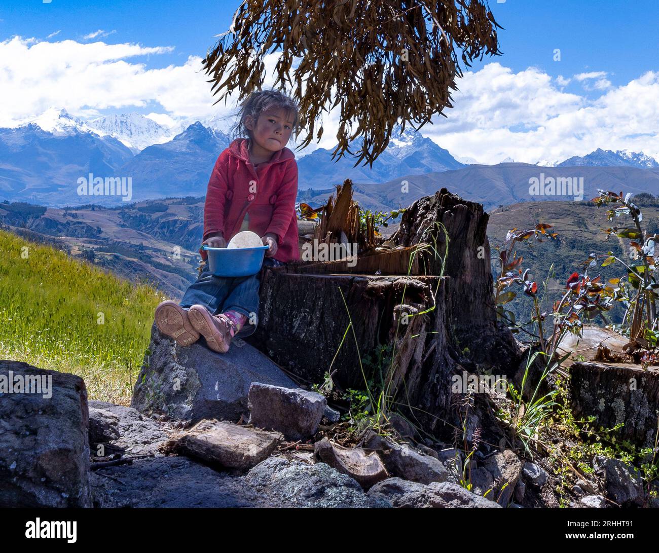 Giovane ragazza peruviana di fronte alla vista panoramica della catena montuosa della Cordillera Blanca dall'escursione al lago Churup vicino a Huaraz, in Perù Foto Stock