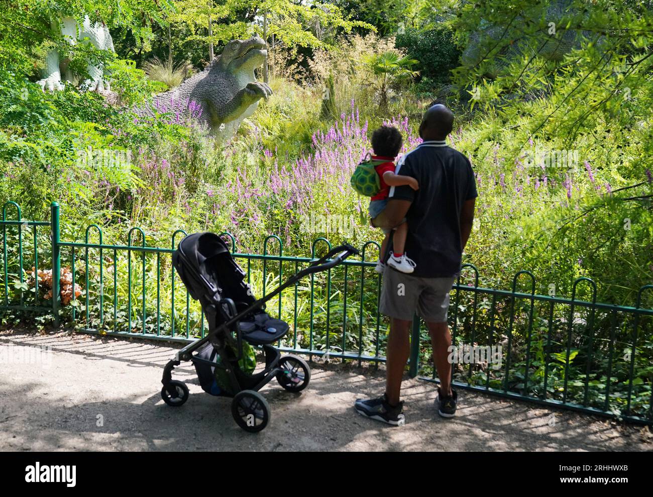 I visitatori del Crystal Palace Park, Londra, osservano una serie di sculture di dinosauri. Commissionati nel 1852 per accompagnare il Palazzo di cristallo dopo il suo trasferimento dalla grande esposizione a Hyde Park, sono stati svelati nel 1854 come le prime sculture di dinosauri al mondo. I modelli, noti anche come Dinosaur Court, sono stati classificati come edifici classificati di grado II dal 1973, ampiamente restaurati nel 2002 e aggiornati al grado i elencato nel 2007. Data foto: Giovedì 17 agosto 2023. Foto Stock