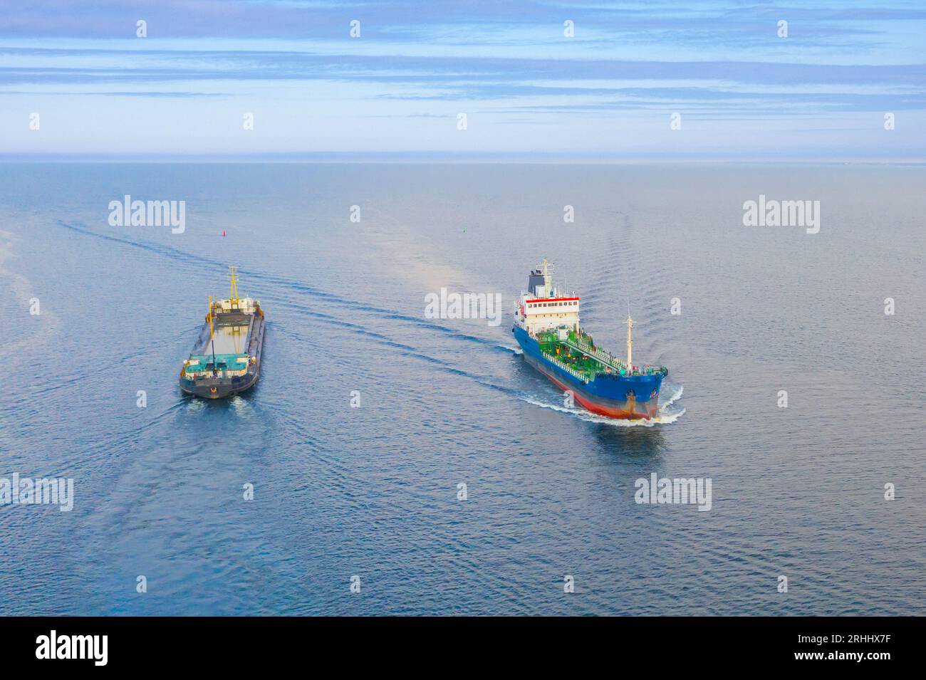 Le navi da carico divergono nella baia, navigano in direzioni diverse, vista aerea del movimento delle navi Foto Stock