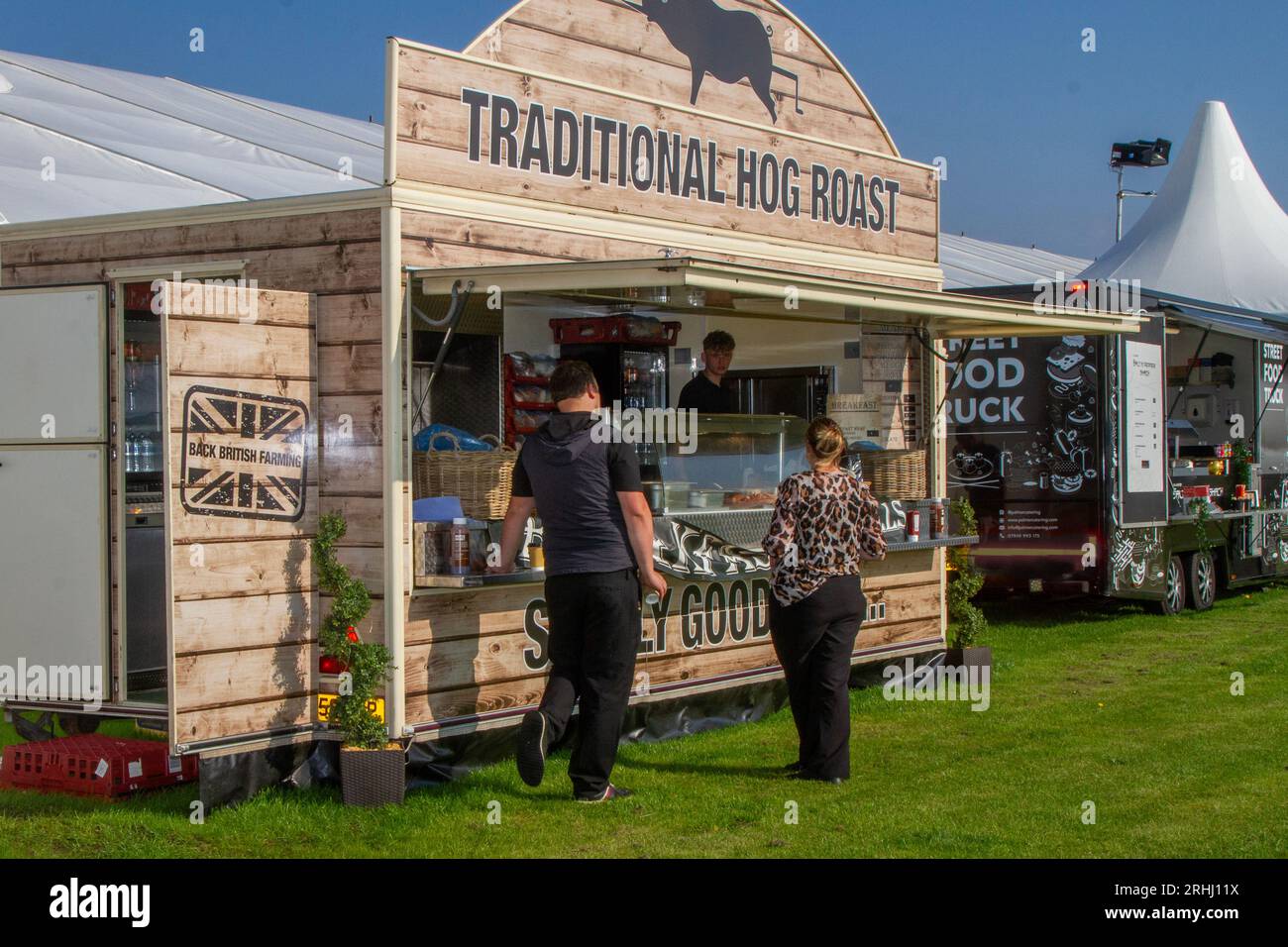 Catering per eventi. Barbecue con arrosto di maiale. Carne di maiale "Pig Pickin" arrostita tradizionale cucinata su un'unità di girarrosto al Southport Flower Show, 2023 Foto Stock