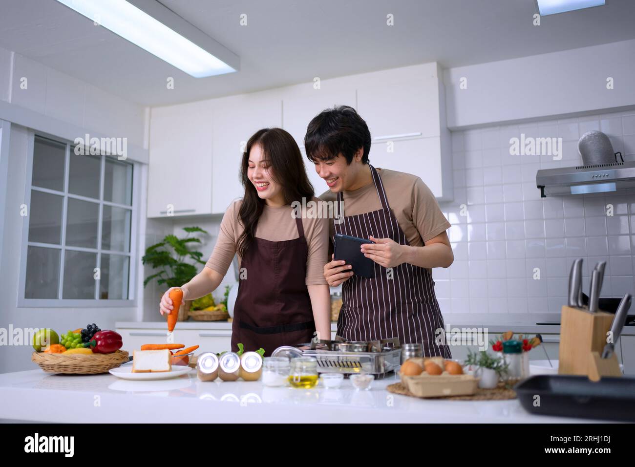 La giovane coppia sta trasmettendo in diretta in cucina. Stile di vita e attività ricreative. Foto Stock