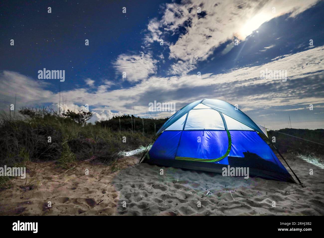 tenda blu che cammina su una spiaggia di notte con un cielo stellato Foto Stock