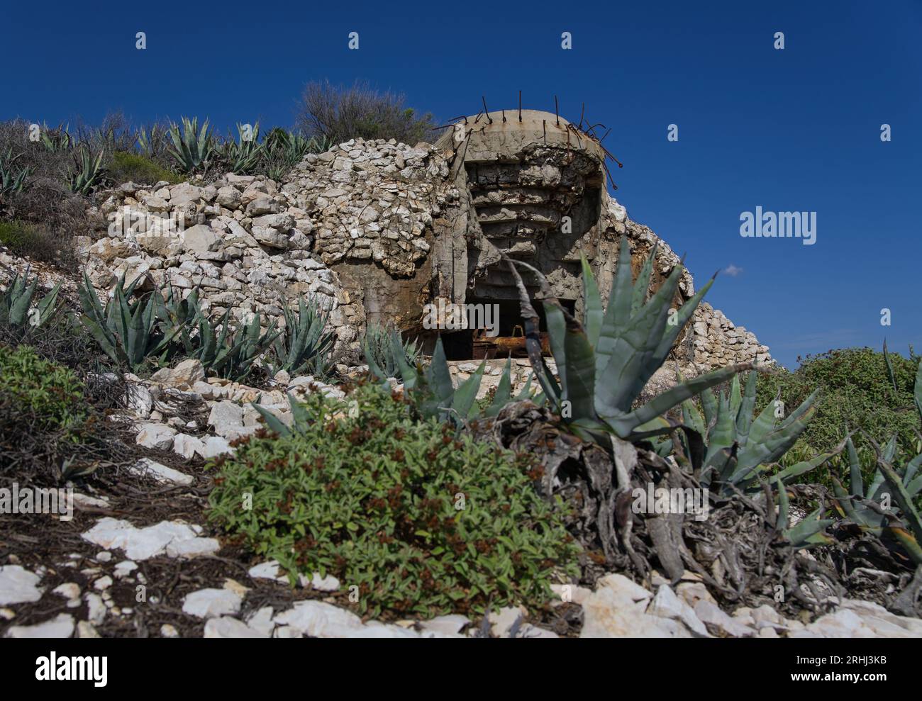 Posizione di artiglieria e mortai antica e abbandonata con ingresso a Bunker sulla pendenza di Una montagna sul mare Foto Stock