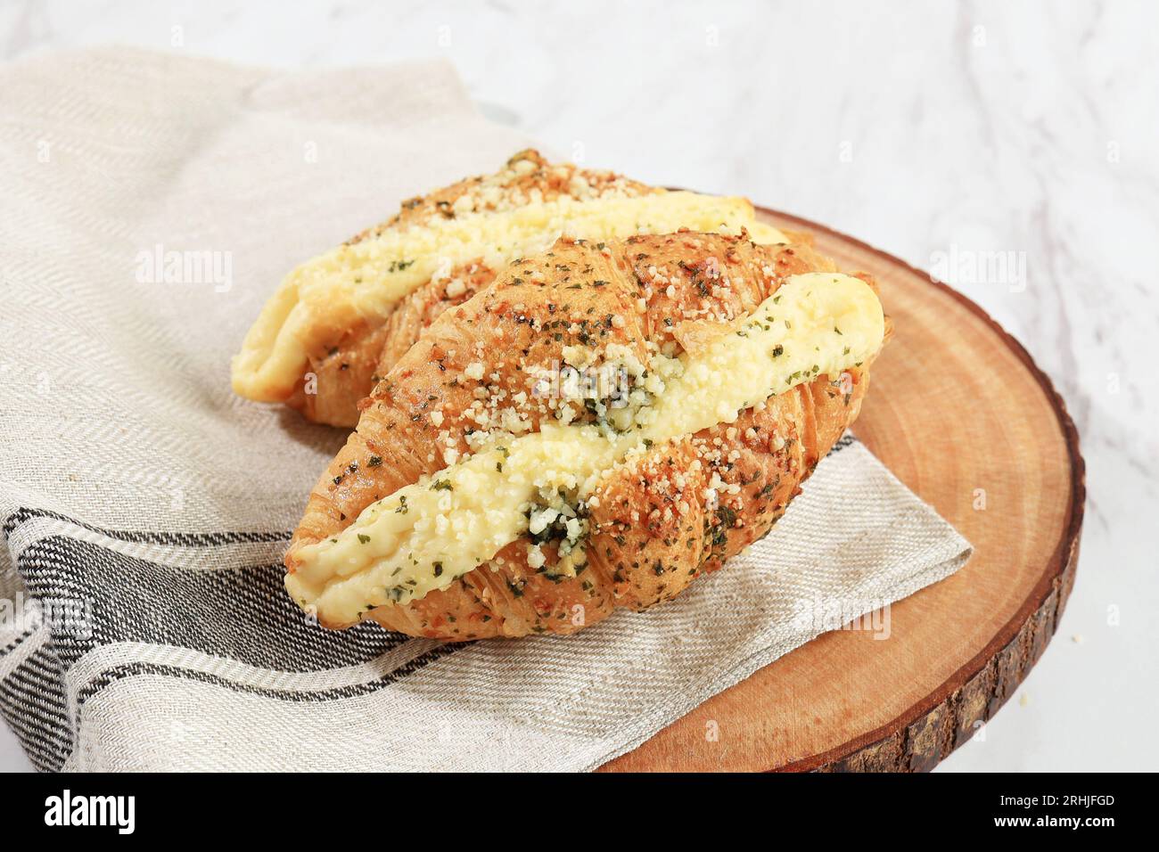 Croissant morbido al formaggio all'aglio, pasticceria al forno con aglio tritato, fiocchi di origano e salsa di formaggio cremoso. Menu di panetteria in stile coreano Foto Stock