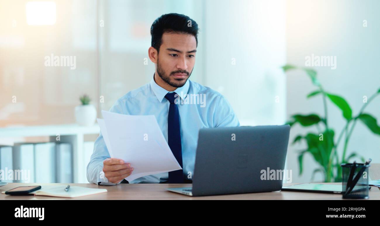 Un giovane che lavora al suo notebook in un ufficio frustrato, stressato e arrabbiato per un cattivo rapporto di vendita dopo una campagna di marketing. Business manager Foto Stock