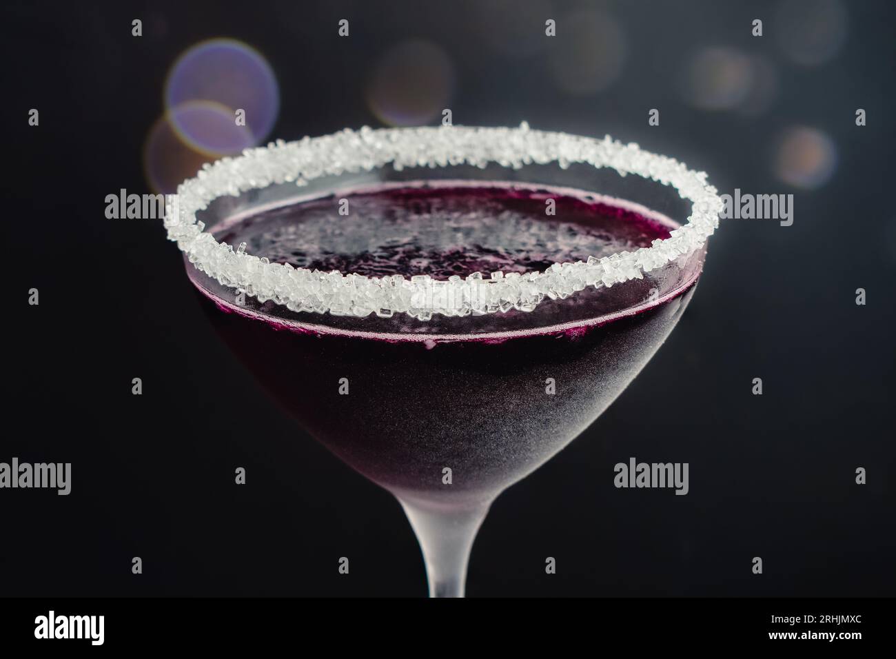 Martini ai mirtilli con bordo zuccherato: Un cocktail preparato con vodka e succo di mirtillo servito in un bicchiere di martini ghiacciato Foto Stock Martini ai mirtilli con bordo zuccherato: Un cocktail preparato con vodka e succo di mirtillo servito in un bicchiere di martini ghiacciato Foto Stock