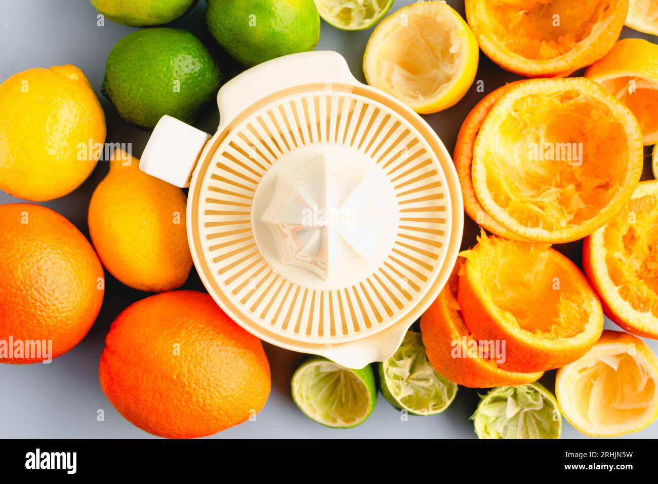 Centrifuga elettrica circondata da agrumi vista dall'alto: Una centrifuga elettrica circondata da arance, limoni e limoni interi e succhi Foto Stock