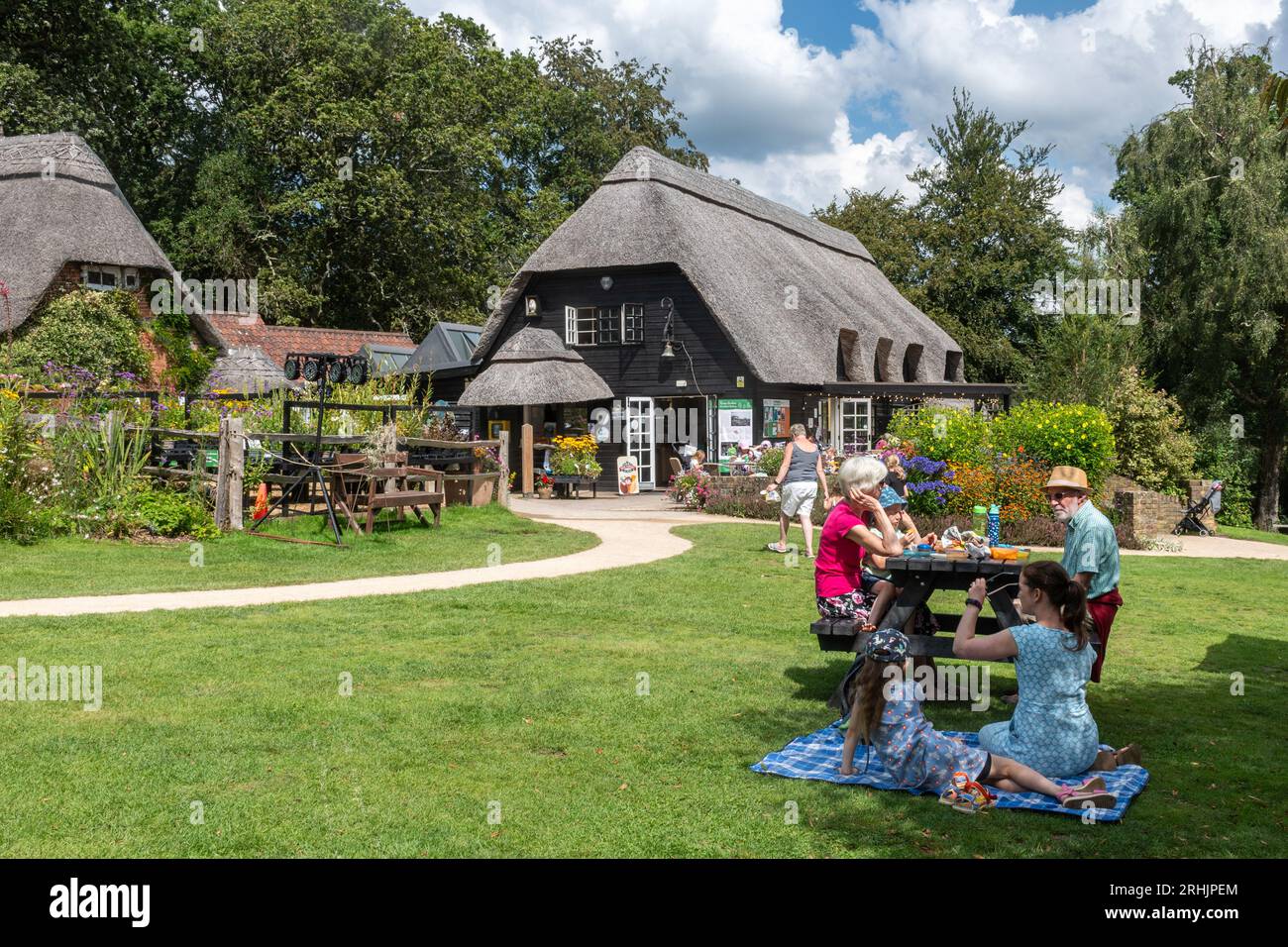 Furzey Gardens, un'attrazione turistica nel New Forest National Park, Hampshire, Inghilterra, Regno Unito, durante l'estate. Persone che pranzano nell'area picnic Foto Stock