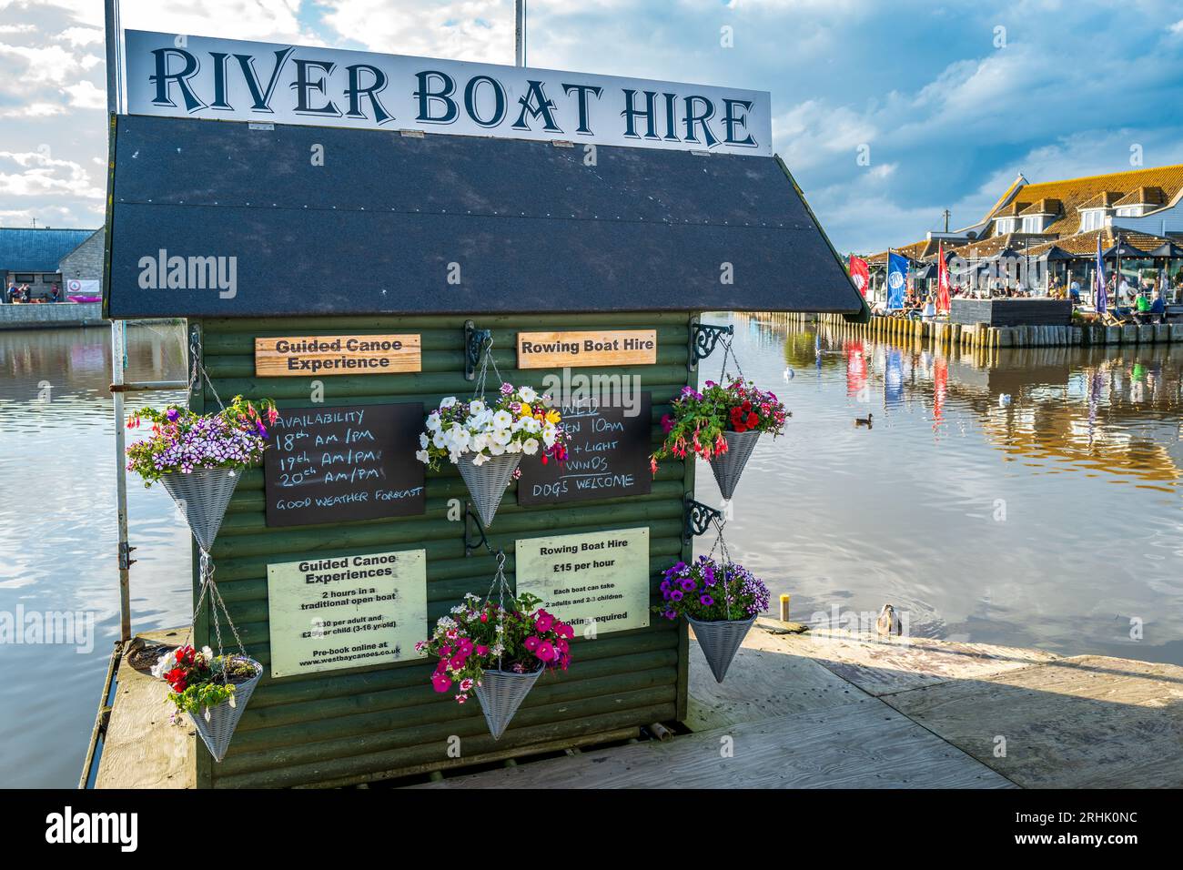 Noleggio barche presso la banchina cittadina nella splendida cittadina portuale del Dorset, West Bay, Bridport, nel sud-ovest, Inghilterra. Scena fluviale. Colorato. Estate. Foto Stock