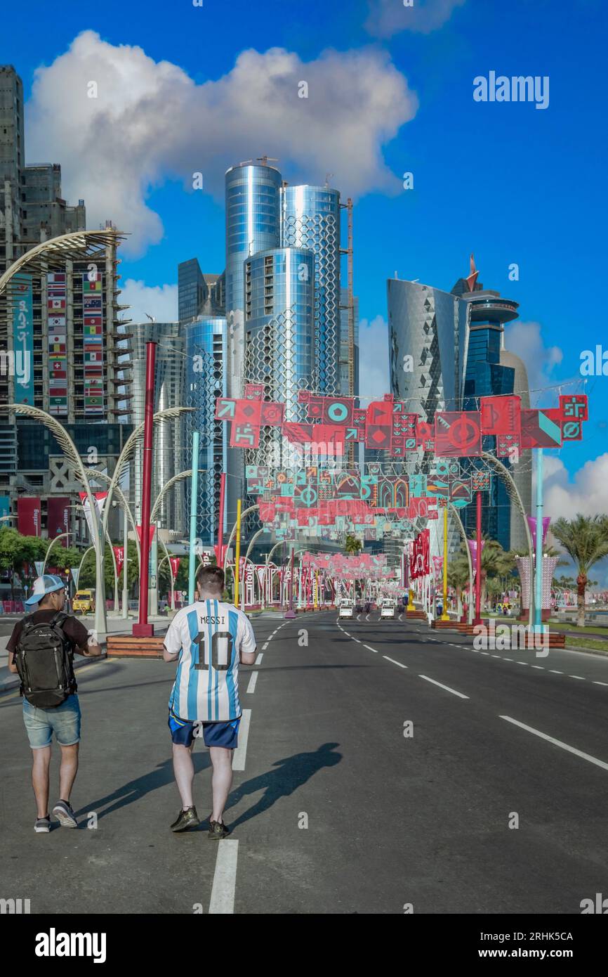 Nell'elettrizzante Coppa del mondo FIFA 2022 del Qatar, un tifoso cattura un momento sincero. Due amici passeggiano nella zona dei tifosi Corniche, il loro palmo eccitante Foto Stock