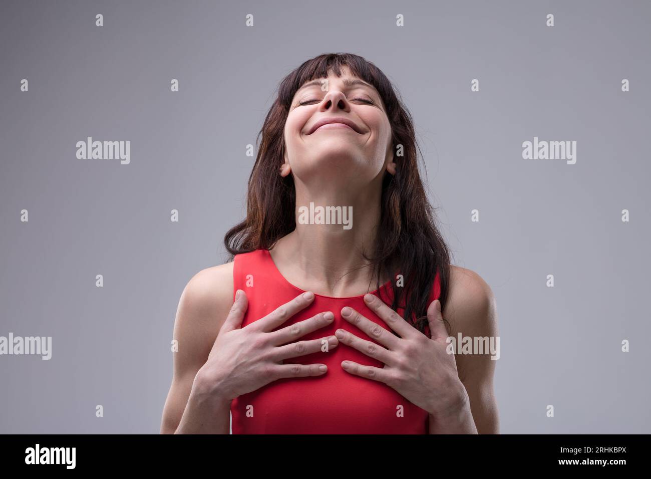 la donna respira profondamente, trasuda soddisfazione e piacere. L'aria la riempie, la vita diventa gioia. Sente positività, profumo della natura, e la V del mondo Foto Stock