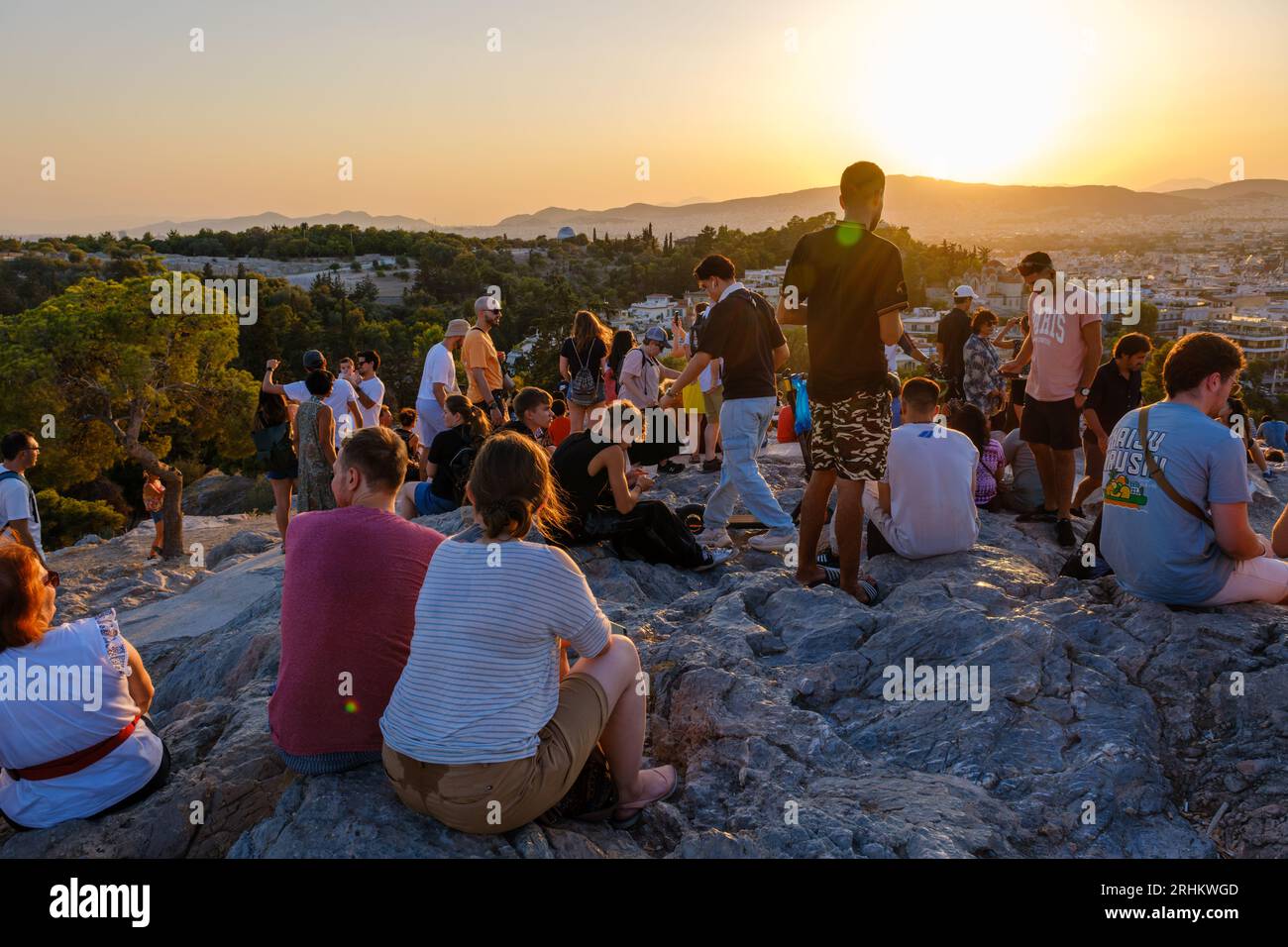 Atene, GR - 29 luglio 2023: Persone che guardano il tramonto sulla collina di Areopago Foto Stock