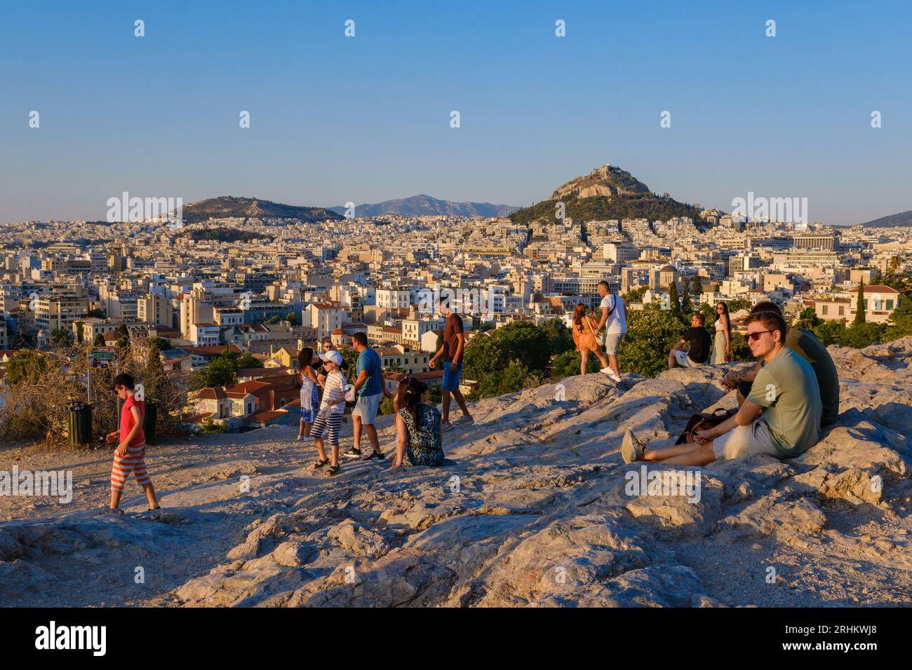 Atene, GR - 29 luglio 2023: Persone che guardano il tramonto sulla collina di Areopago Foto Stock