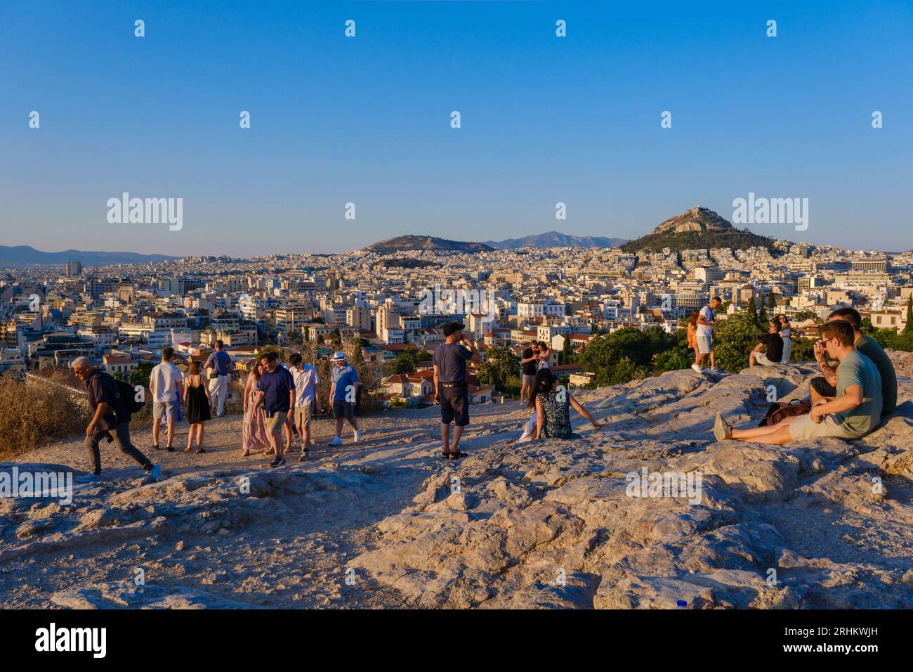 Atene, GR - 29 luglio 2023: Persone che guardano il tramonto sulla collina di Areopago Foto Stock