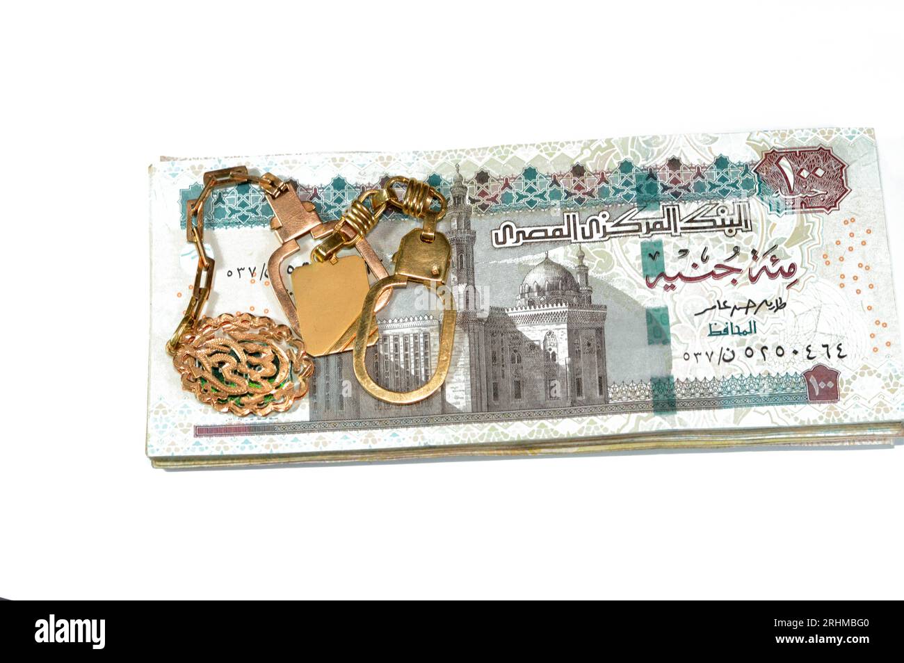 Sfondo di medaglie d'oro di carati d'oro 18 con testo arabo Allahu Akbar traduzione (Dio è il più grande), su pila di egizi 100 LE Foto Stock