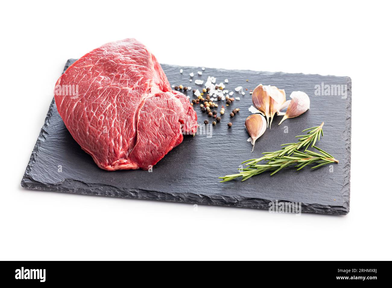 Filetto crudo di carne di manzo su tagliere isolato su fondo bianco. Foto Stock