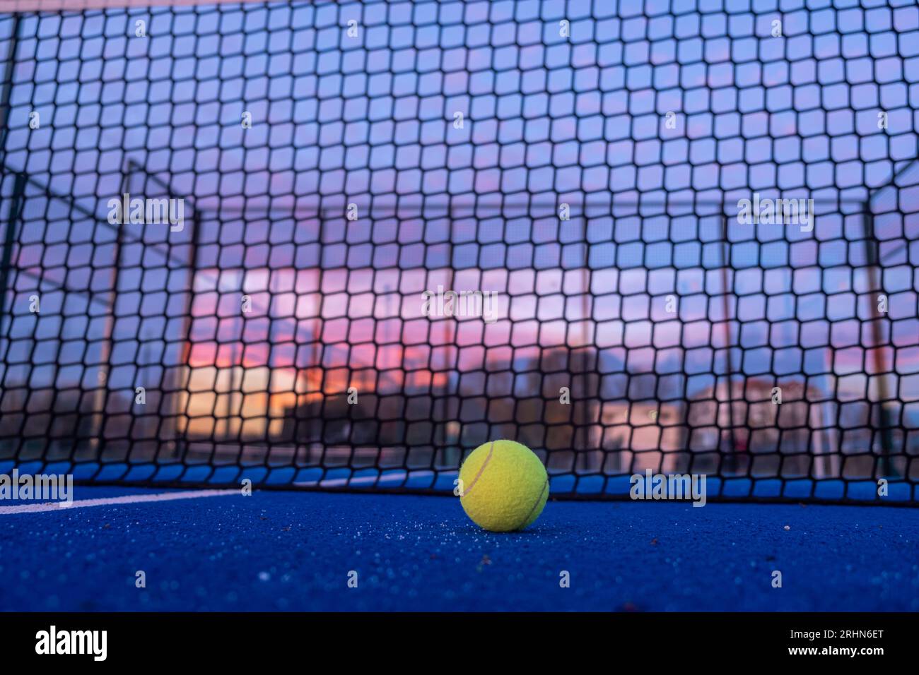 concentrazione selettiva, una palla su un campo da paddle tennis al calar della notte Foto Stock