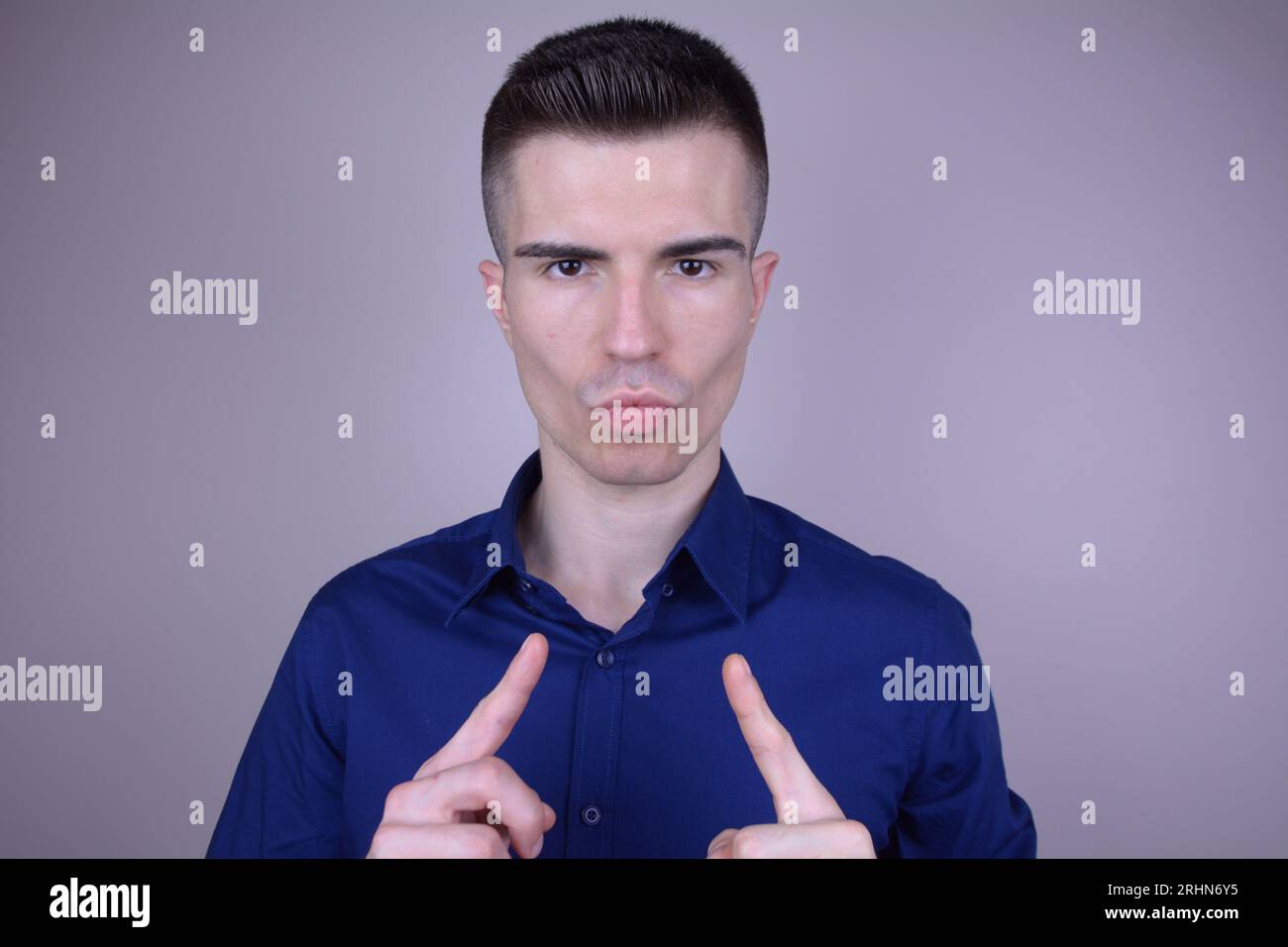 Troppo sicuro bello giovane elegante uomo caucasico che punta a se stesso su sfondo isolato Foto Stock