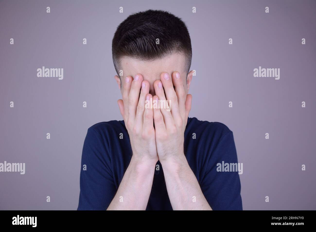 Uomo caucasico che copre il volto con entrambe le mani su sfondo isolato Foto Stock