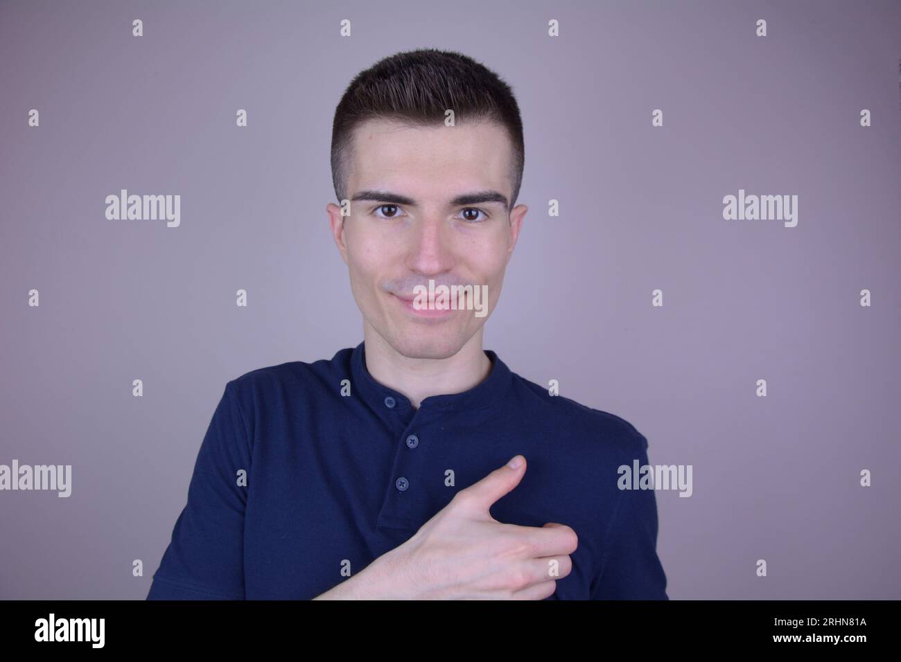 Bell'uomo caucasico tiene l'oggetto invisibile in mano per la pubblicità su sfondo isolato Foto Stock