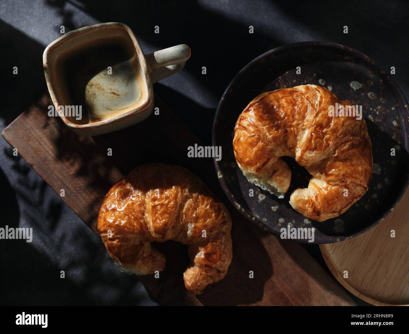 Una tazza di caffè caldo con croissant Foto Stock