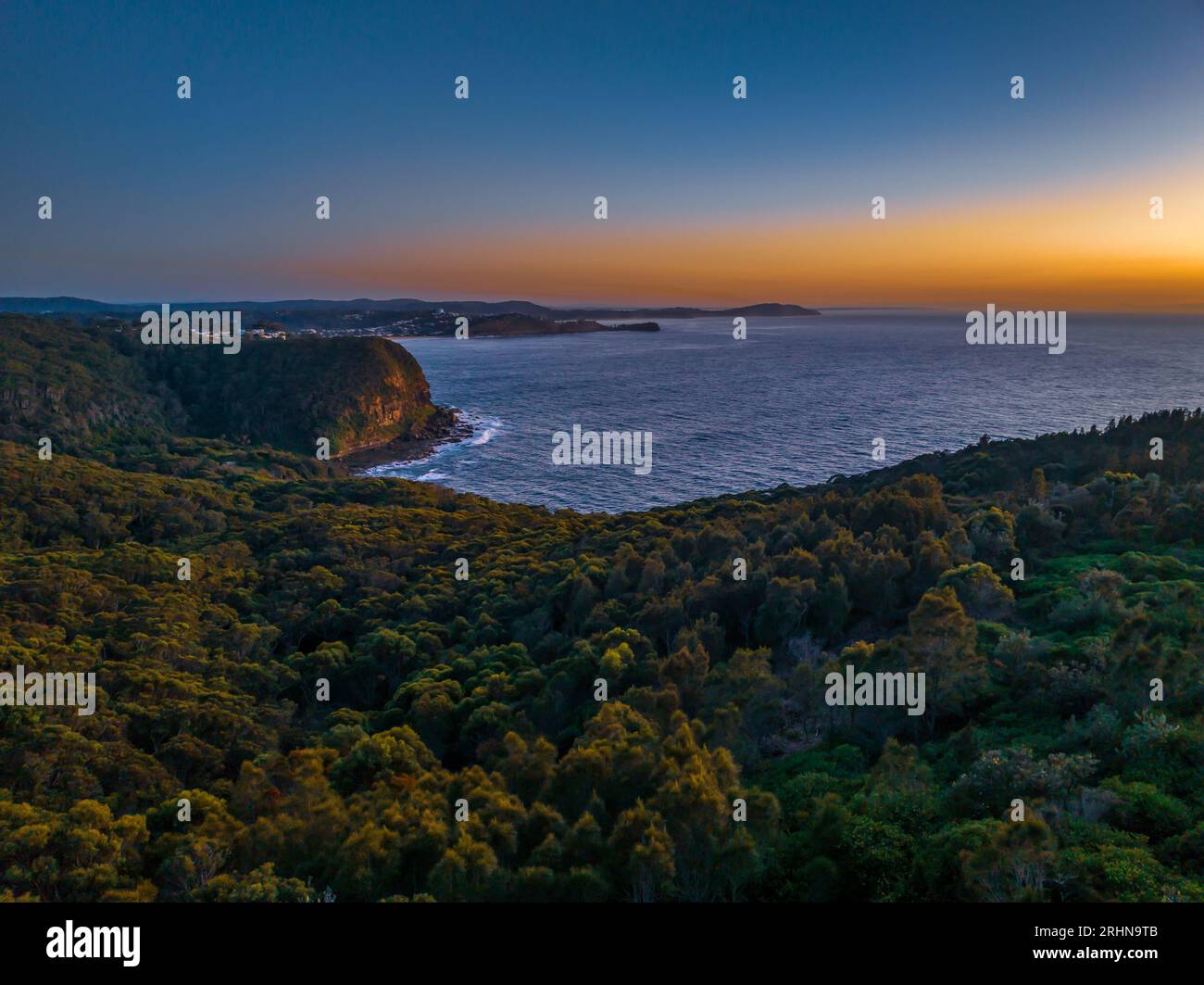 Vista dell'alba sul mare e sulla foresta dal Captain Cook Lookout a Copacabana, sulla costa centrale del New South Wales, Australia. Foto Stock