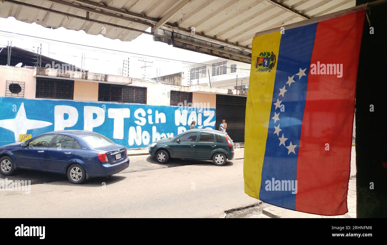 Un'immagine raffigurante la bandiera del Venezuela accanto a uno slogan politico in spagnolo sul muro indica che una patria non può esistere senza mais Foto Stock