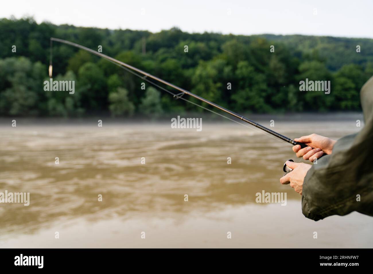 Primo piano delle mani di un pescatore con una canna da pesca Foto Stock