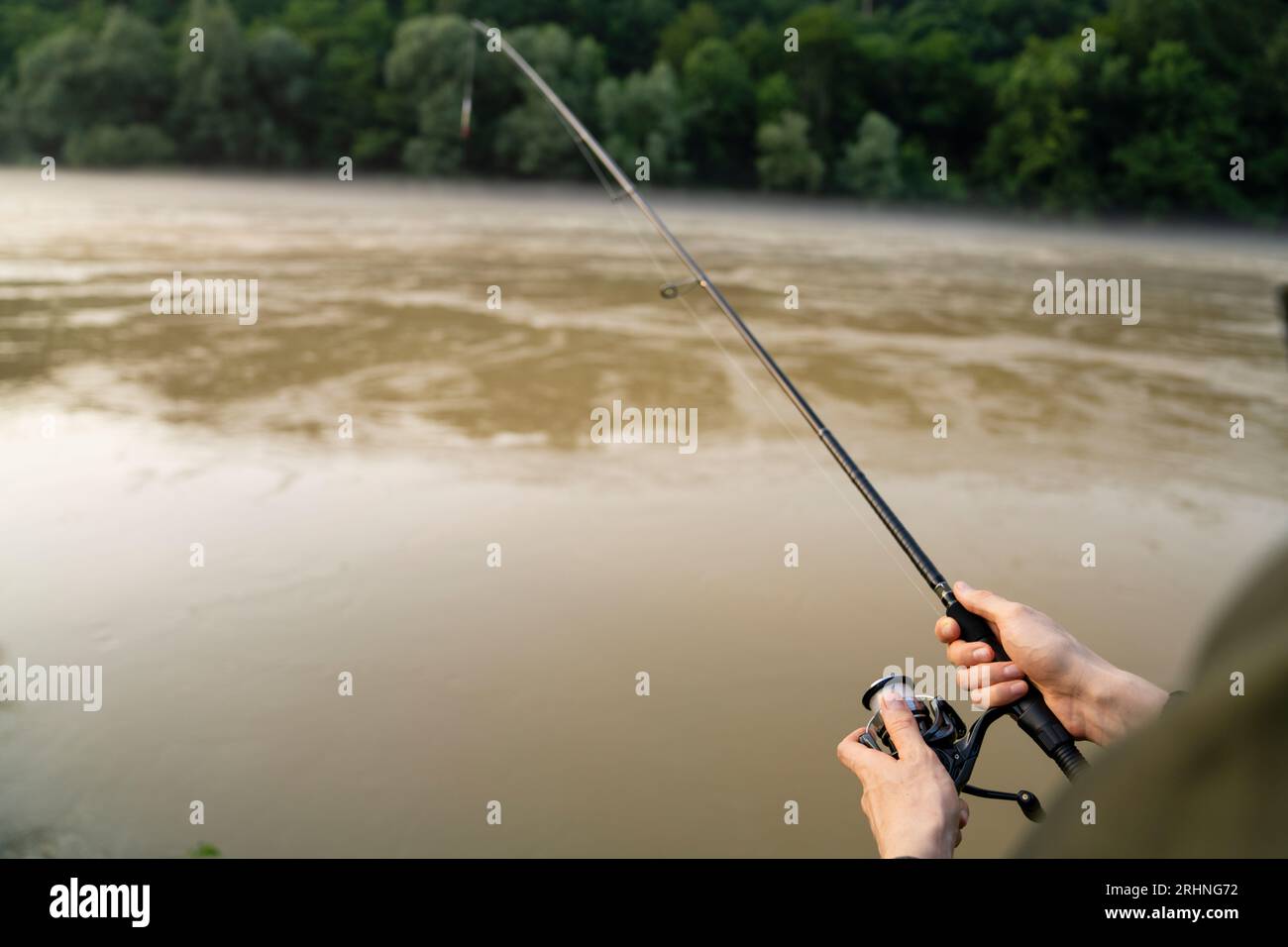 Primo piano delle mani di un pescatore con una canna da pesca Foto Stock