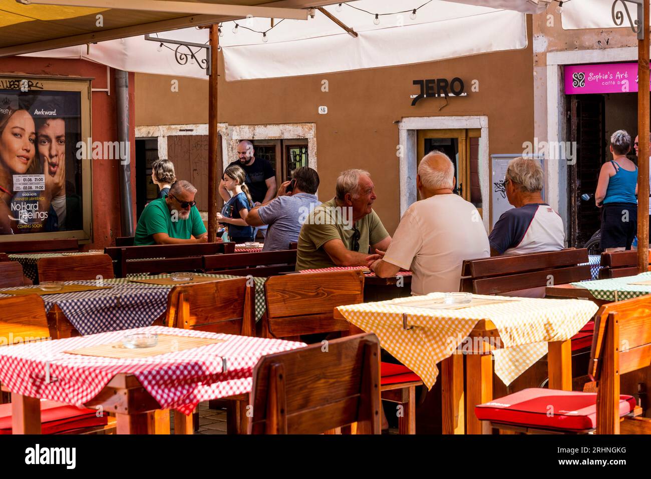 Persone sedute in un caffè locale in via Grisia, la strada pedonale principale, Rovigno, Istria, Croazia Foto Stock