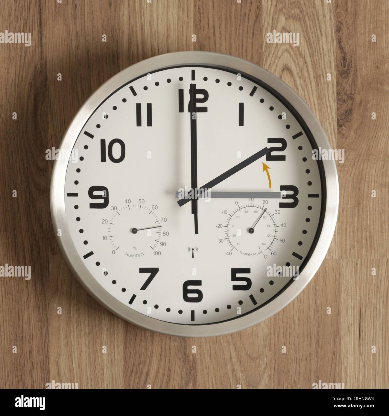 Un orologio, la mano grigia punta alle tre, quella nera alle due. La freccia arancione indica la direzione di movimento delle mani. Symbo Foto Stock