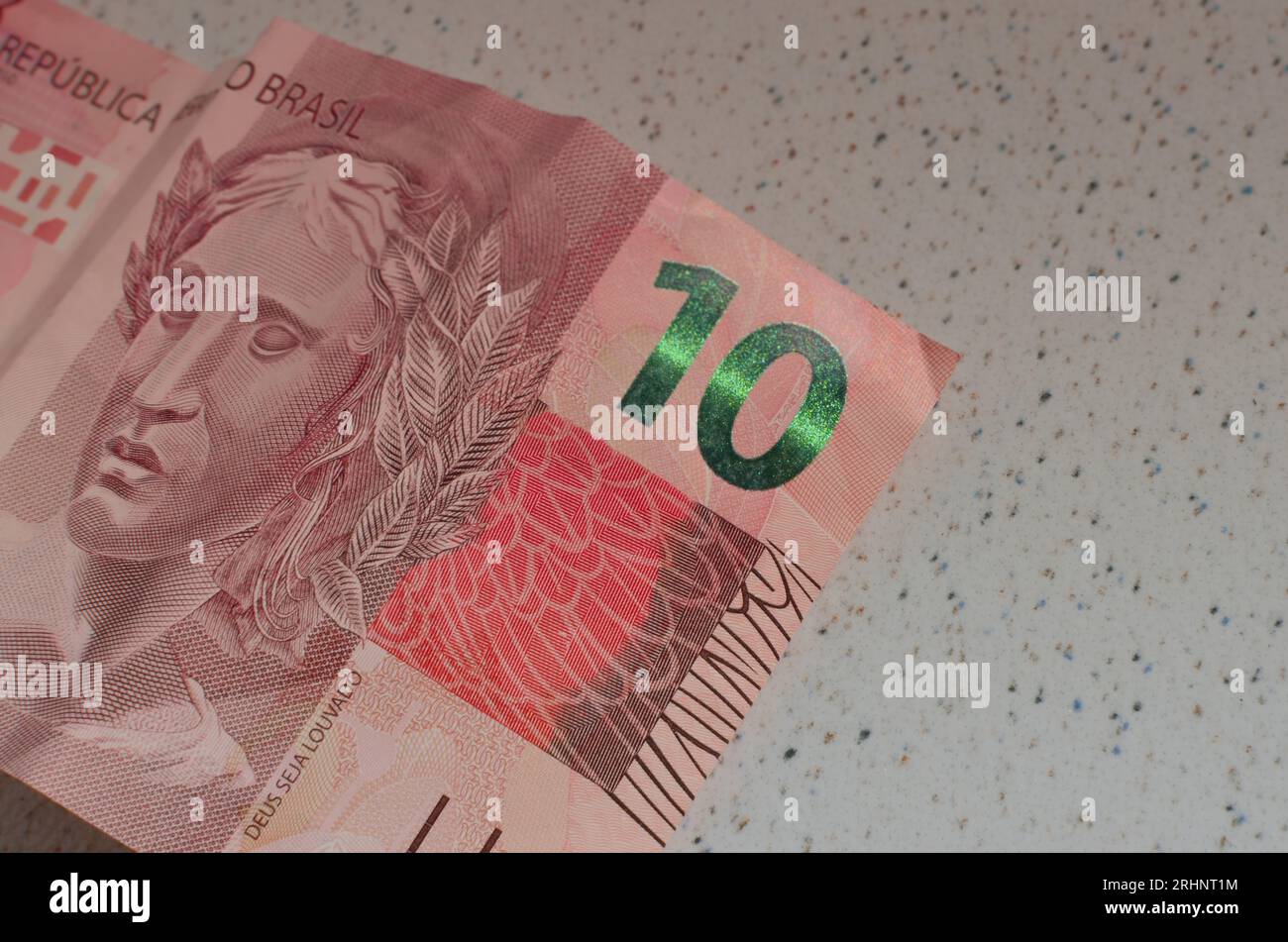 Dettaglio della banconota da 10 reais do Brasil, una valuta brasiliana evidenziata dal suo emblematico colore rosso. Casa da Moeda do Brasil, rappresentante la B. Foto Stock